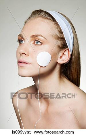 Woman with facial toning pad on cheek View Large Photo Image Stock Photography - Woman with facial toning pad on cheek. Fotosearch