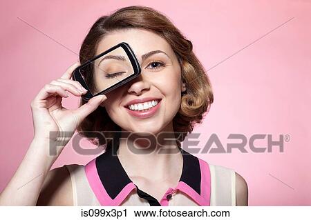 Stock Image - Woman with smartphone over eye. Fotosearch