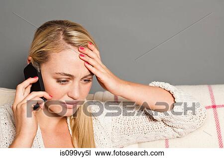 Stock Image - Worried woman on cell phone. Fotosearch