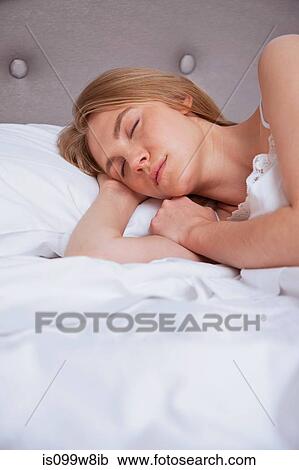 Young woman asleep in bed View Large Photo Image Stock Image - Young woman asleep in bed. Fotosearch