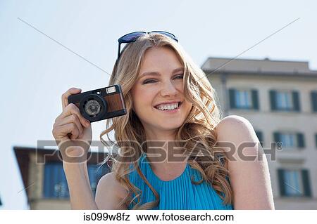 Stock Photo - Young woman holding vintage camera. Fotosearch