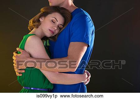 Young woman hugging boyfriend with closed eyes View Large Photo Image Stock Photography - Young woman hugging boyfriend with closed eyes. Fotosearch