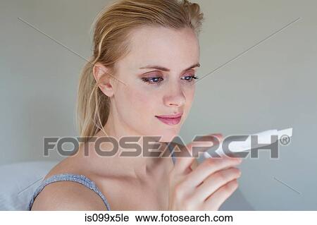 Young woman looking at pregnancy test View Large Photo Image Stock Image - Young woman looking at pregnancy test. Fotosearch