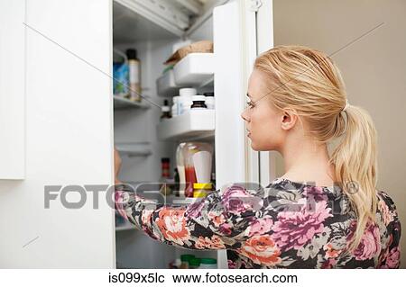 Young woman looking in refrigerator View Large Photo Image Stock Image - Young woman looking in refrigerator. Fotosearch