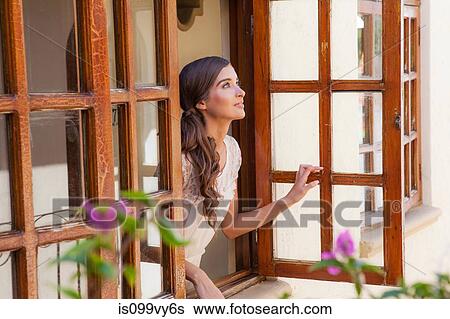 Young woman looking out of window View Large Photo Image Stock Photograph - Young woman looking out of window. Fotosearch