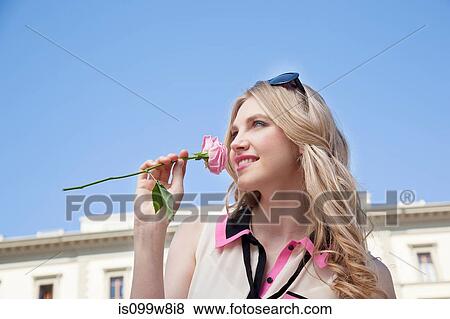 Young woman outdoors smelling rose View Large Photo Image Stock Photo - Young woman outdoors smelling rose. Fotosearch