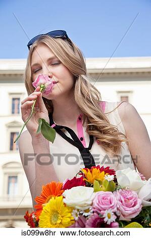 Young woman smelling rose from bouquet of flowers, eyes closed View Large Photo Image Stock Photography - Young woman smelling rose from bouquet of flowers, eyes closed. Fotosearch