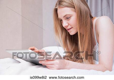 Young woman using digital tablet View Large Photo Image Stock Image - Young woman using digital tablet. Fotosearch