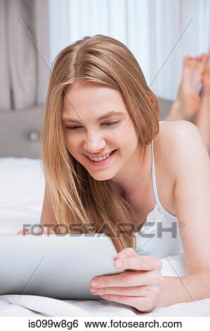 Young woman using digital tablet View Large Photo Image Stock Photograph - Young woman using digital tablet. Fotosearch