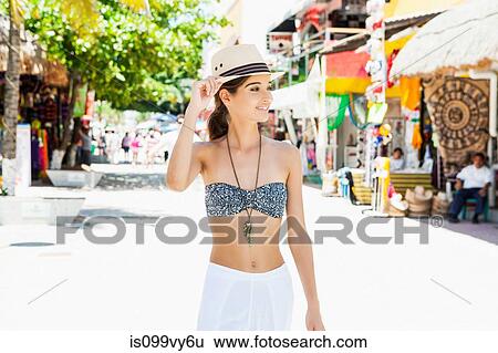 Stock Photograph - Young woman walking down street. Fotosearch