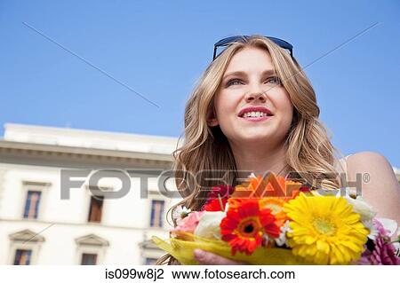 Stock Image - Young woman with bouquet of flowers. Fotosearch