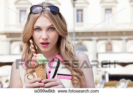 Stock Image - Young woman with ice cream cone. Fotosearch