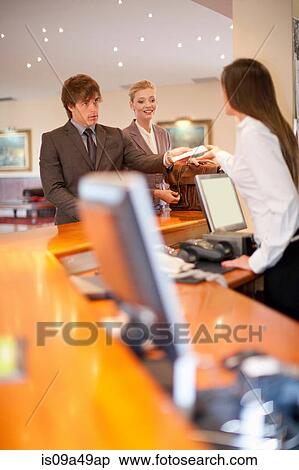 Stock Photography - Business people checking into hotel. Fotosearch