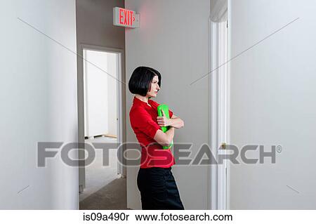 Stock Photography - Businesswoman carrying folder in office. Fotosearch