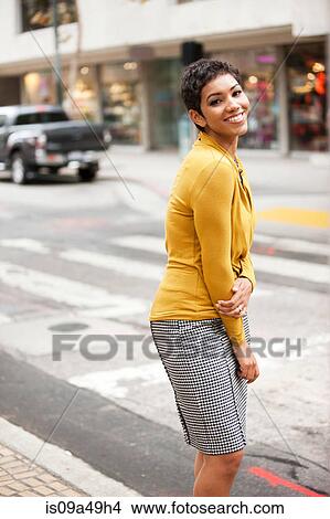 Picture - Businesswoman crossing city street. Fotosearch