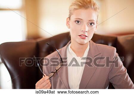 Stock Photograph - Businesswoman holding glasses at desk. Fotosearch