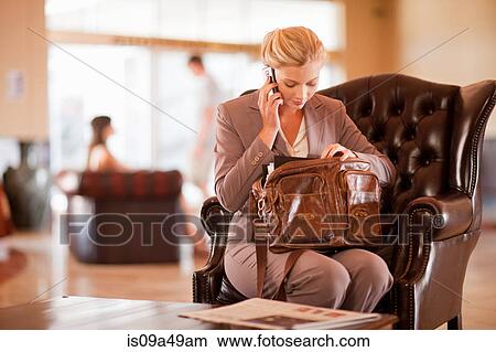 Businesswoman on cell phone in lobby View Large Photo Image Picture - Businesswoman on cell phone in lobby. Fotosearch