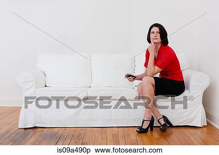 Stock Photography - Businesswoman with cell phone on sofa. Fotosearch