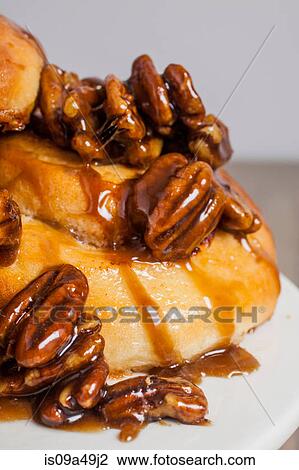 Stock Image - Close up of pecans on sticky buns. Fotosearch