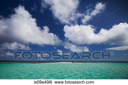 Stock Photograph - Clouds over sandbar and tropical water. Fotosearch