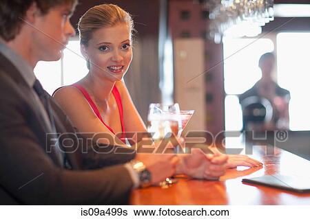 Couple having drinks at bar View Large Photo Image Stock Photograph - Couple having drinks at bar. Fotosearch
