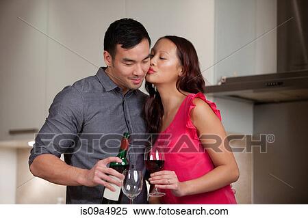 Stock Photography - Couple having wine together in kitchen. Fotosearch