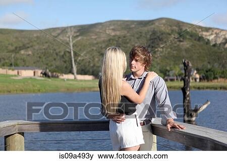 Stock Photo - Couple hugging on wooden deck. Fotosearch