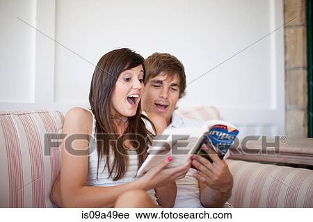 Stock Image - Couple reading travel book together. Fotosearch