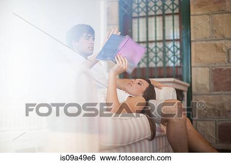 Couple relaxing on sofa together View Large Photo Image Stock Photograph - Couple relaxing on sofa together. Fotosearch
