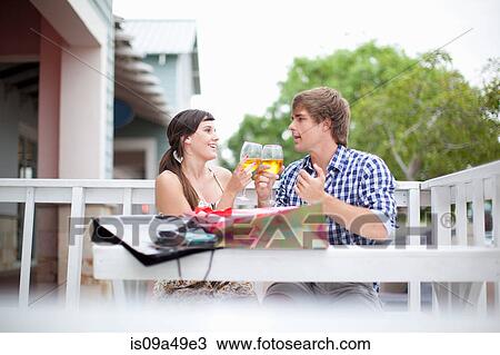 Stock Image - Couple toasting each other with wine. Fotosearch