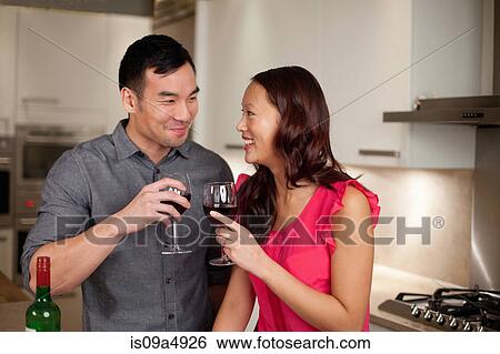 Stock Photograph - Couple toasting each other with wine. Fotosearch