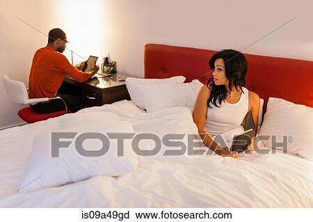 Couple using tablet computers in bedroom View Large Photo Image Stock Image - Couple using tablet computers in bedroom. Fotosearch