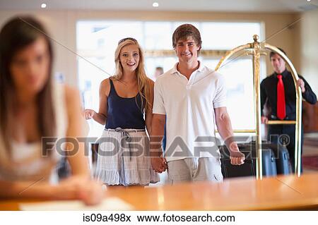 Stock Photo - Couple walking in hotel lobby. Fotosearch