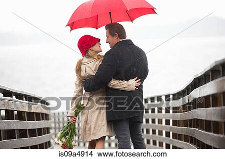 Couple walking on wooden pier in rain View Large Photo Image Picture - Couple walking on wooden pier in rain. Fotosearch