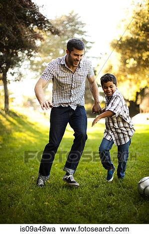 Father and son playing soccer together View Large Photo Image Stock Image - Father and son playing soccer together. Fotosearch