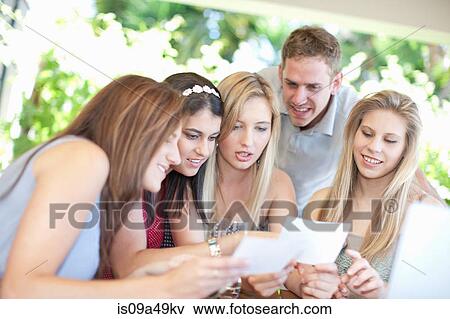Stock Photo - Friends looking at pictures together. Fotosearch