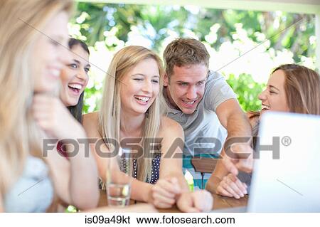Stock Photograph - Friends using laptop together. Fotosearch