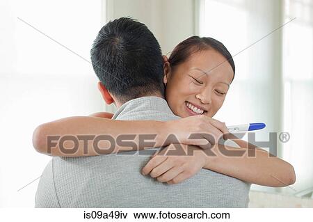 Happy couple taking pregnancy test View Large Photo Image Stock Photo - Happy couple taking pregnancy test. Fotosearch