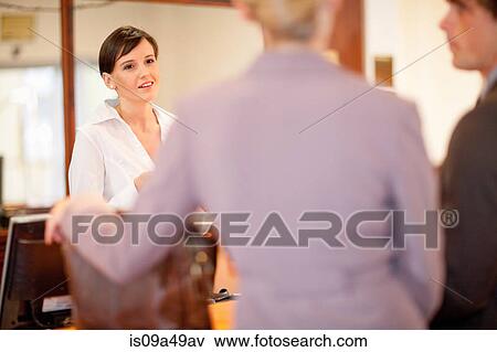 Hotel receptionist talking to guests View Large Photo Image Stock Photo - Hotel receptionist talking to guests. Fotosearch