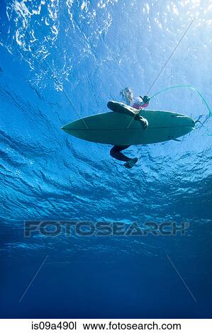 Stock Image - Low angle view of surfer in water. Fotosearch