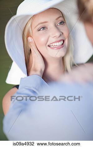 Stock Image - Man adjusting girlfriend's hat. Fotosearch