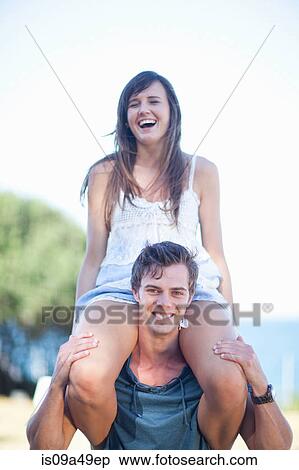 Stock Photography - Man carrying girlfriend outdoors. Fotosearch
