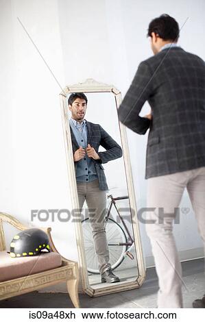 Stock Image - Man examining himself in mirror. Fotosearch