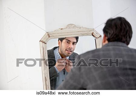 Man examining himself in mirror View Large Photo Image Stock Image - Man examining himself in mirror. Fotosearch