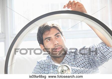 Man fixing bicycle wheel indoors View Large Photo Image Stock Image - Man fixing bicycle wheel indoors. Fotosearch
