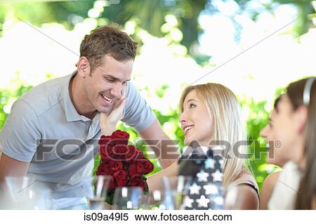 Stock Photography - Man giving girlfriend bouquet of flowers. Fotosearch