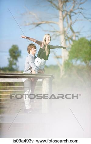 Man holding girlfriend on wooden deck View Large Photo Image Stock Photo - Man holding girlfriend on wooden deck. Fotosearch