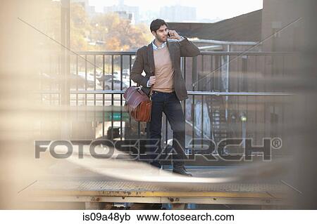 Man on cell phone at train station View Large Photo Image Stock Image - Man on cell phone at train station. Fotosearch