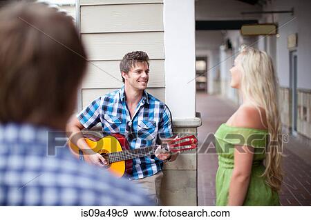 Stock Photo - Man playing guitar for girlfriend. Fotosearch