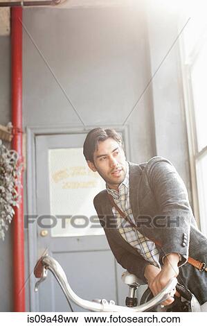 Man pushing bicycle indoors View Large Photo Image Stock Photo - Man pushing bicycle indoors. Fotosearch